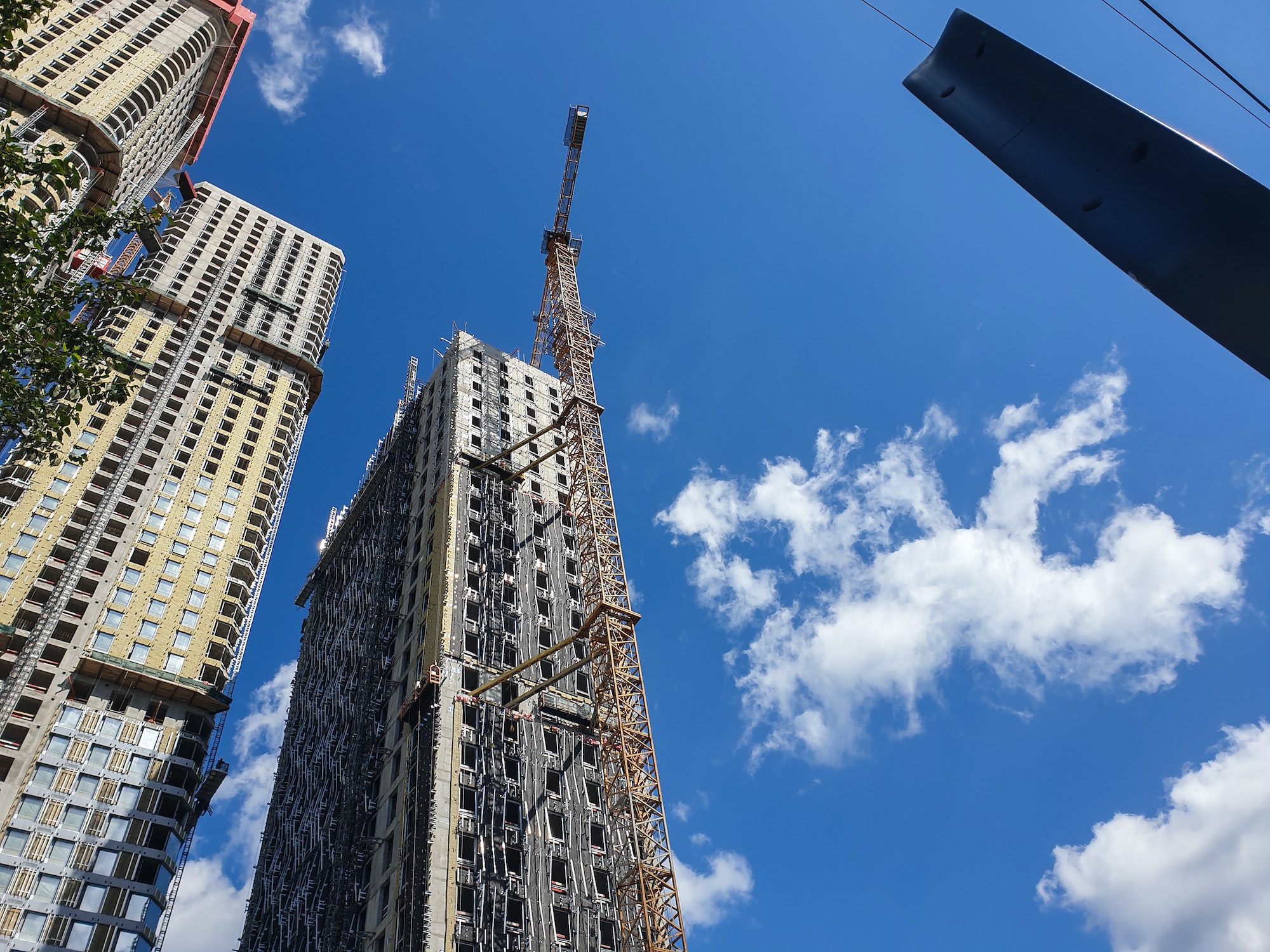 Modern process of skyscraper site construction or tall buildings on blue sky background